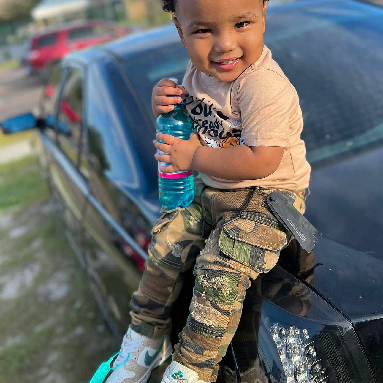 Tyrese is registered to the contest to win money with this photo: blackhair, bottle, boy, bumper, child, clothing, curlyhair, face, hair, head, jeans, male, military, militaryuniform, pants, person, shaker, sitting, sleeve, soldier