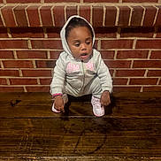 Serenity joined the competition — help win amazing prizes! toddler, child, hoodie, sneakers, bench, wood, brick_wall, squatting, curious, indoors, casual_clothing, young_child, person, face, expression, fashion, floor, candid, portrait, small_child