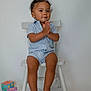 toddler, child, chair, blue_striped_clothing, hands_clasped, barefoot, indoor, white_background, toy_blocks, cute, smiling, short_hair, sitting, playful, person, young_child, studio, minimalist, portrait, happy
