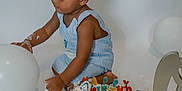 Caden is registered to the contest to win money with this photo: toddler, child, birthday, cake, balloon, blue_clothing, celebration, frosting, messy, party, indoor, smiling, one_year_old, colorful, sprinkles, white_background, happy, sitting, hands, cute