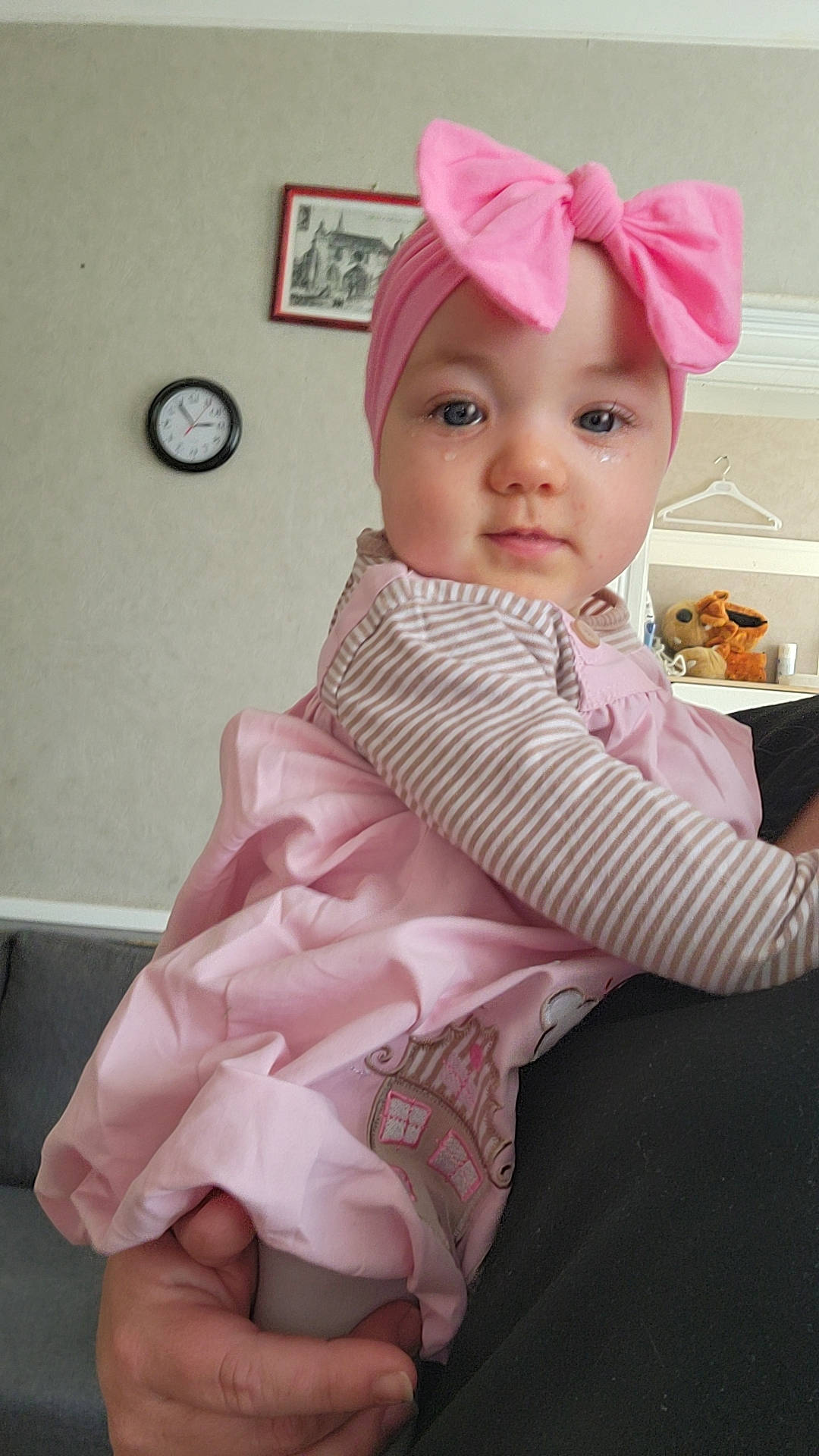 Lyna participe au concours pour gagner de l'argent avec cette photo : baby, baby_products, baby_toddler_clothing, child, clock, comfort, dress, eye, fashion_accessory, hair_accessory, happy, headgear, headwear, linens, magenta, pattern, person, pink, room, sitting