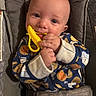 James joined the competition — help win amazing prizes! baby, infant, teething_toy, blue_pajamas, cookie_pattern, milk_carton_pattern, cushion, baby_seat, hands, face, smile, chewing, cute, child, indoor, closeup, person, apparel, fabric, comfort