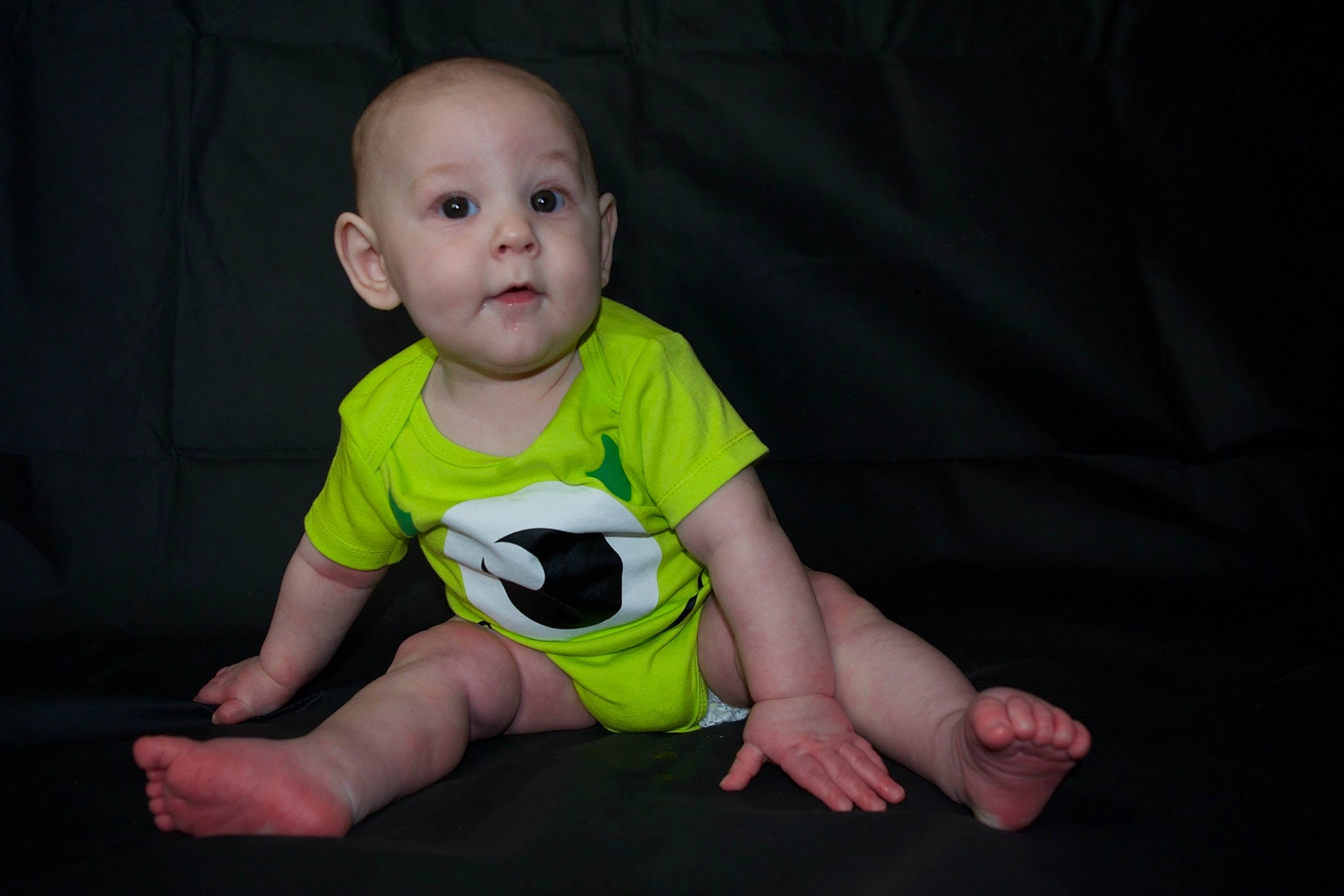 Connor is registered to the contest to win money with this photo: baby, baby_toddler_clothing, cheek, comfort, elbow, eye, face, flash_photography, floor, flooring, fun, grass, hairstyle, happy, head, iris, knee, person, sleeve, surprise