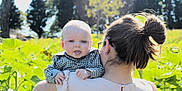 Raymond joined the competition — help win amazing prizes! baby, child, person, adult, hair_bun, glasses, earrings, checkered_shirt, outdoor, nature, greenery, trees, sunlight, shoulder, holding, tongue_out, face, head, daylight, field