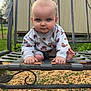 Raymond is registered to the contest to win money with this photo: baby, bench, blue_eyes, child, clothing, crawling, cute, expression, face, feet, grass, gravel, hands, metal, nature, outdoor, pattern, person, portrait, shed