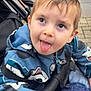 Maho participe au concours pour gagner de l'argent avec cette photo : blue_jacket, cartoon_print, child, closeup, clothing, cute, expression, face, fun, hand, jacket, outdoor, pavement, person, playful, seated, stroller, toddler, tongue_out, young