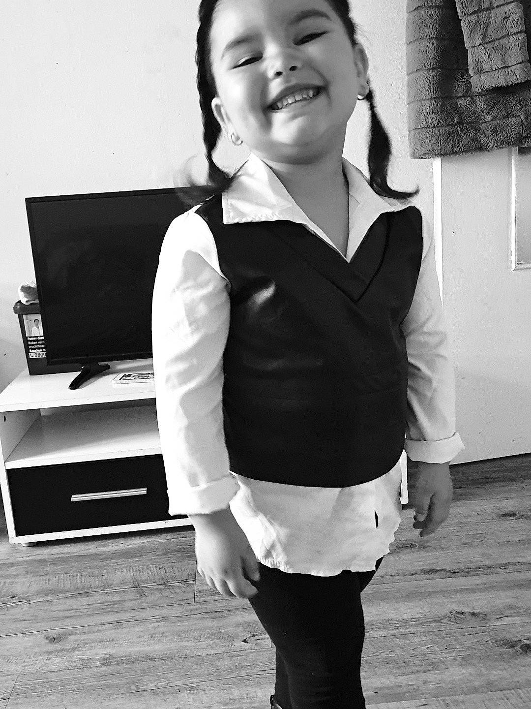 Maïssa a rejoint le concours — aidez-le/la à gagner de superbes lots ! black, black_and_white, eye, face, facial_expression, flash_photography, gesture, happy, head, joy, monochrome, neck, person, photograph, shoulder, sleeve, smile, standing, style, toddler