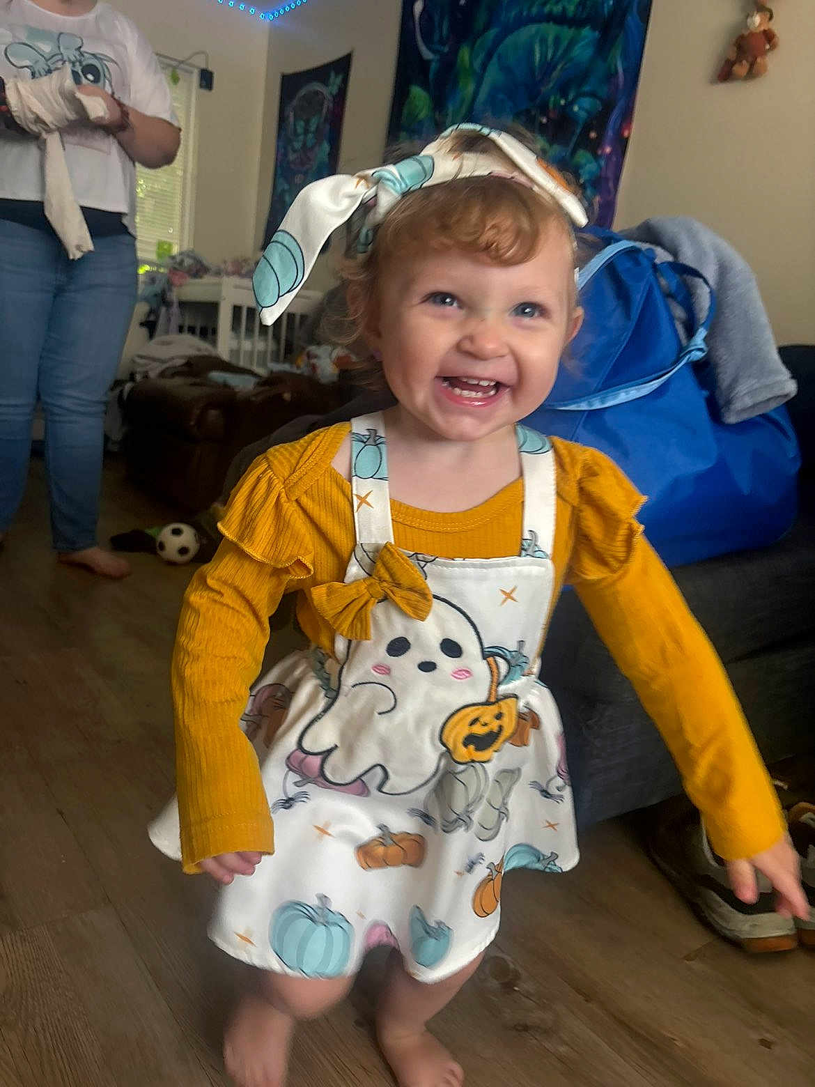 Cerenity joined the competition — help win amazing prizes! toddler, child, smiling, happy, indoor, barefoot, yellow_shirt, dress, headband, halloween, ghost, pumpkin, floor, toy, furniture, person, living_room, curtains, bag, jeans