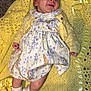 Dolores is registered to the contest to win money with this photo: baby, infant, child, yellow_blanket, crochet, dress, cardigan, socks, floor, carpet, smiling, lying_down, cute, soft_texture, ribbons, floral_pattern, comfortable, happy, indoors, portrait