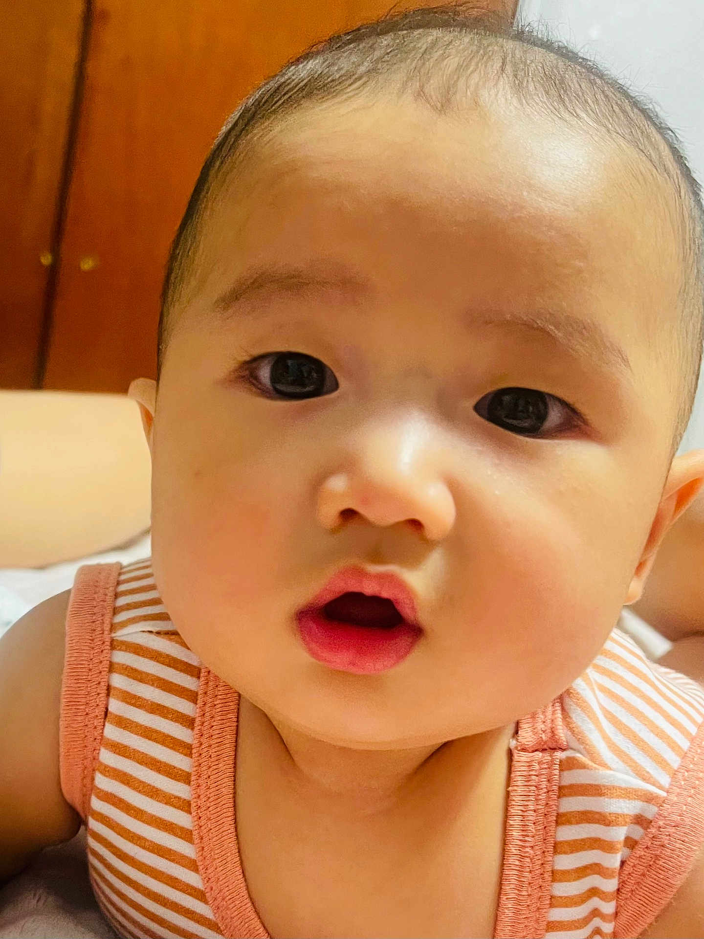Theodore is registered to the contest to win money with this photo: baby, infant, face, closeup, eyes, mouth, skin, expression, curious, child, person, striped_clothing, sleeveless, indoors, portrait, head, young, cute, adorable, babywear