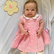 Lily joined the competition — help win amazing prizes! baby, infant, smile, pink_dress, white_collar, lying_down, blanket, milestone, wooden_plaque, flower_shape, cute, child, portrait, happy, four_months, skin, hands, legs, socks, indoor