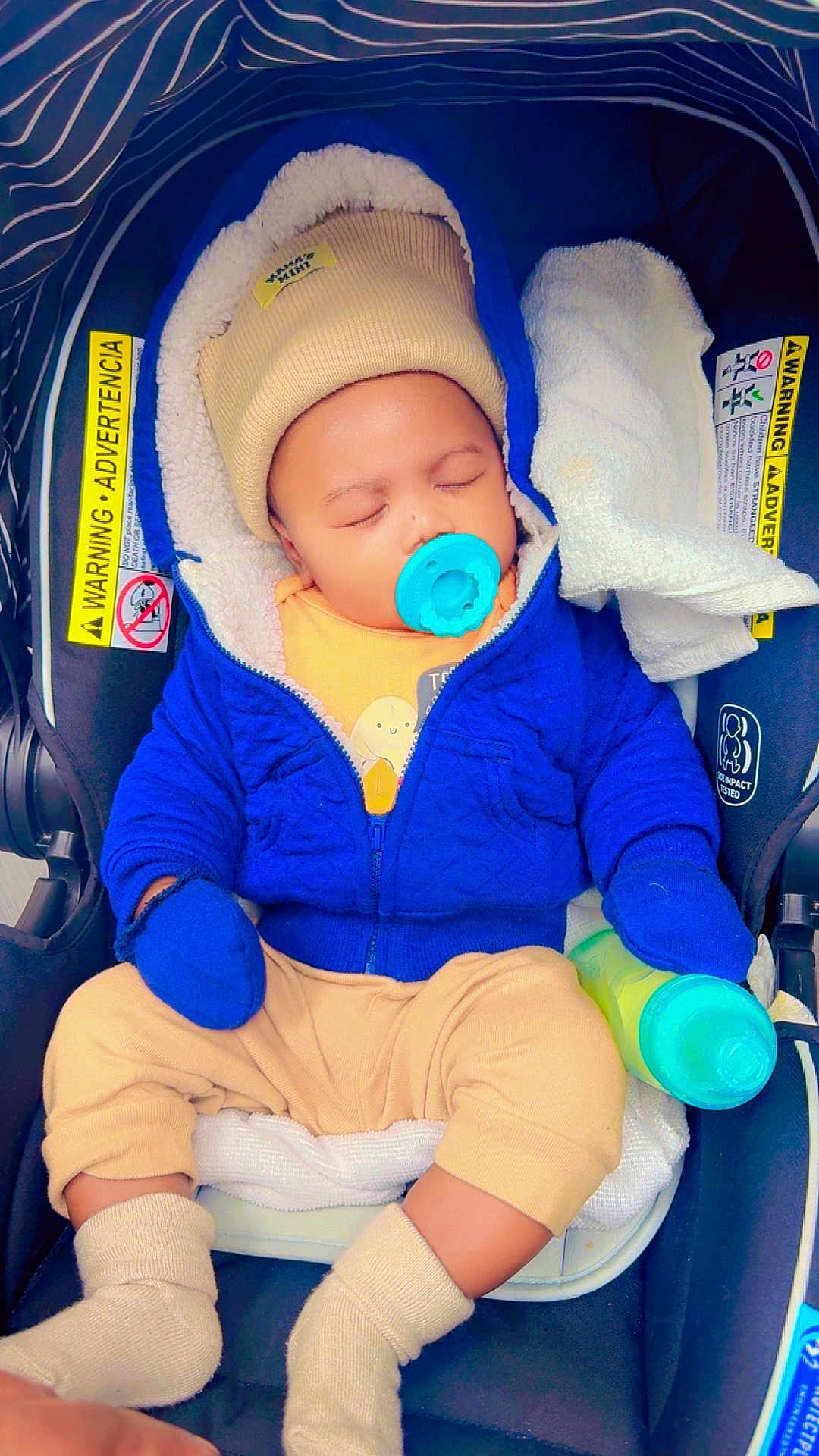 David Kaiden joined the competition — help win amazing prizes! baby, beige_clothes, blanket, blue_jacket, car_seat, cute, hat, hood, infant, mittens, newborn, pacifier, parent_hand, safety_label, seatbelt, sippy_bottle, sleeping, socks, soft_lining, striped_canopy
