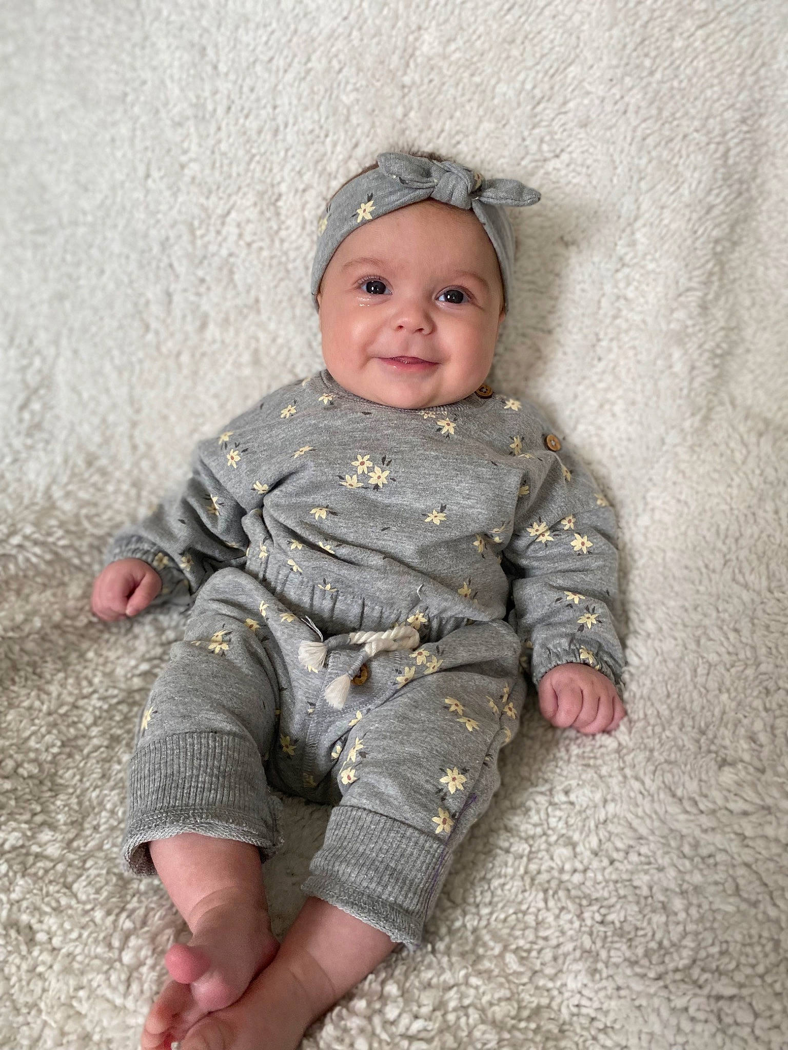 Lillian joined the competition — help win amazing prizes! baby, baby_toddler_clothing, cheek, child, eye, face, foot, grass, hand, head, headwear, human_body, human_leg, joy, pattern, person, personal_protective_equipment, sitting, skin, sleeve