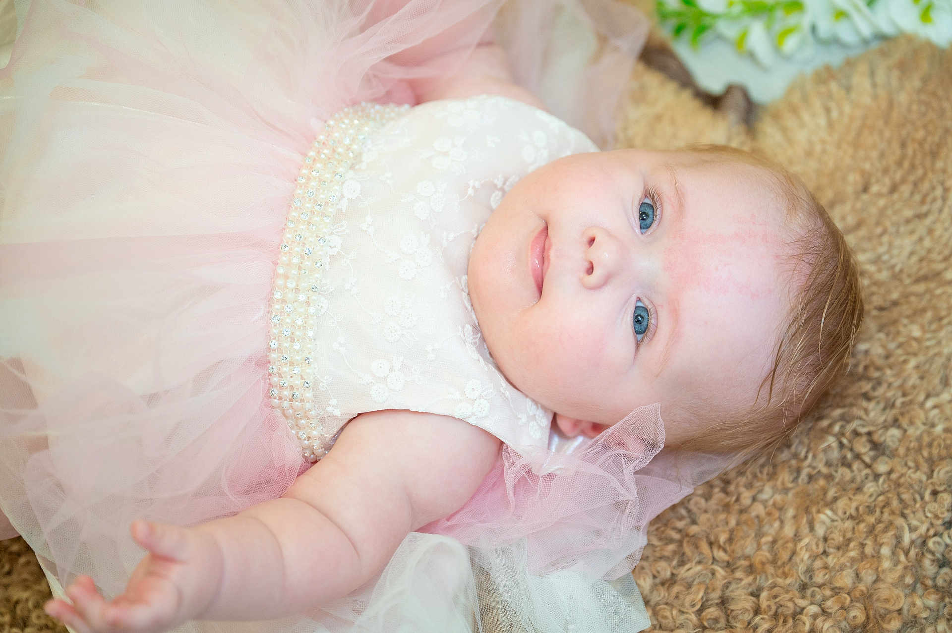 Maisy joined the competition — help win amazing prizes! baby, infant, dress, pink, white, lace, pearls, tulle, blue_eyes, skin, arm, hand, lying_down, soft_texture, cozy, cute, portrait, child, newborn, closeup