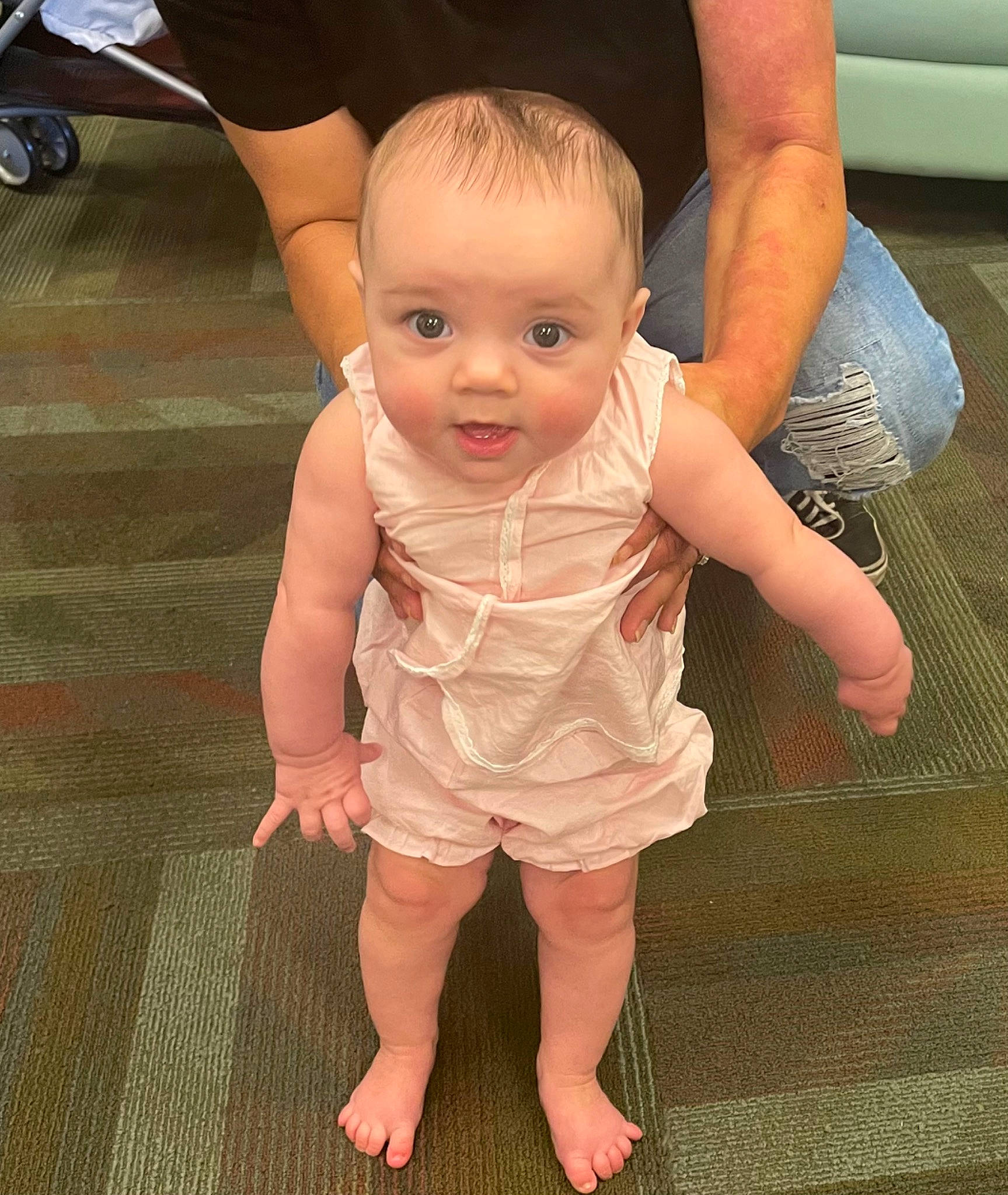 Thalia is registered to the contest to win money with this photo: baby, baby_toddler_clothing, barefoot, cheek, finger, floor, flooring, foot, gesture, hair, happy, head, human_leg, joint, nail, person, skin, thigh, thumb, toddler