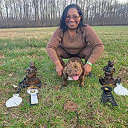 Oso-Sunny joined the competition — help win amazing prizes! person, dog, grass, trophy, ribbon, outdoor, field, smile, happy, award, pet, nature, leafless_trees, crouching, sunlight, celebration, competition, canine, leash, casual_clothing