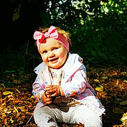 Molly joined the competition — help win amazing prizes! baby, child, smiling, outdoor, nature, autumn, leaves, headband, pink, jacket, barefoot, happy, sitting, forest, fall, cute, person, young, playful, sunlight