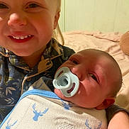 Alden joined the competition — help win amazing prizes! baby, bed, blanket, child, clothing, comfort, expression, face, family, happy, holding, indoor, infant, newborn, pacifier, person, skin, smiling, swaddle, toddler