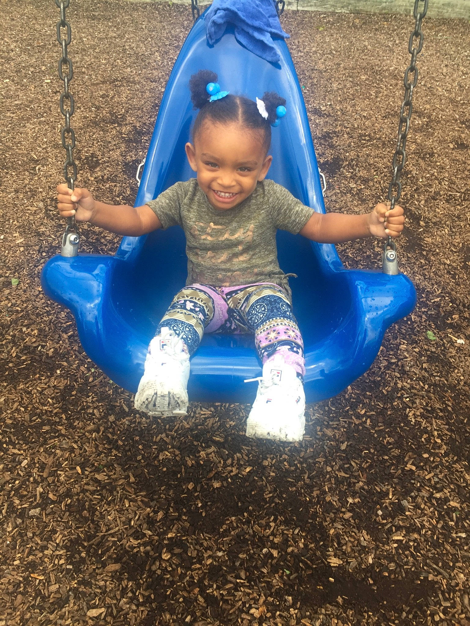 Amyah is registered to the contest to win money with this photo: blue, child, city, fun, grass, human_settlement, joy, leisure, outdoor_play_equipment, person, plant, play, playground, playground_slide, public_space, recreation, smile, soil, swing, toddler