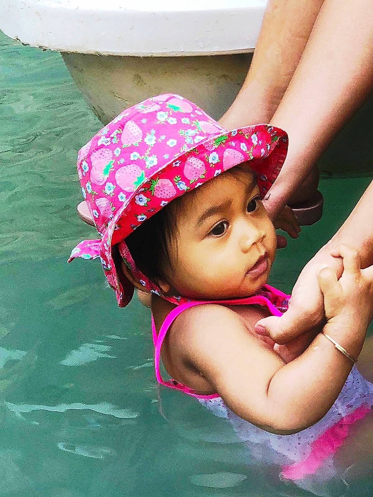 Angie participe au concours pour gagner de l'argent avec cette photo : child, fashion_accessory, fun, girl, happiness, headgear, headwear, leisure, person, pink, product, skin, smile, summer, sun_hat, swimwear, toddler, vacation
