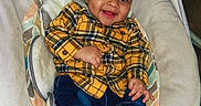 Musa joined the competition — help win amazing prizes! baby, baby_seat, brown_shoes, child, clothing, cushion, cute, face, footwear, happy, indoor, infant, jeans, person, plaid, portrait, seated, smiling, tongue_out, yellow_shirt