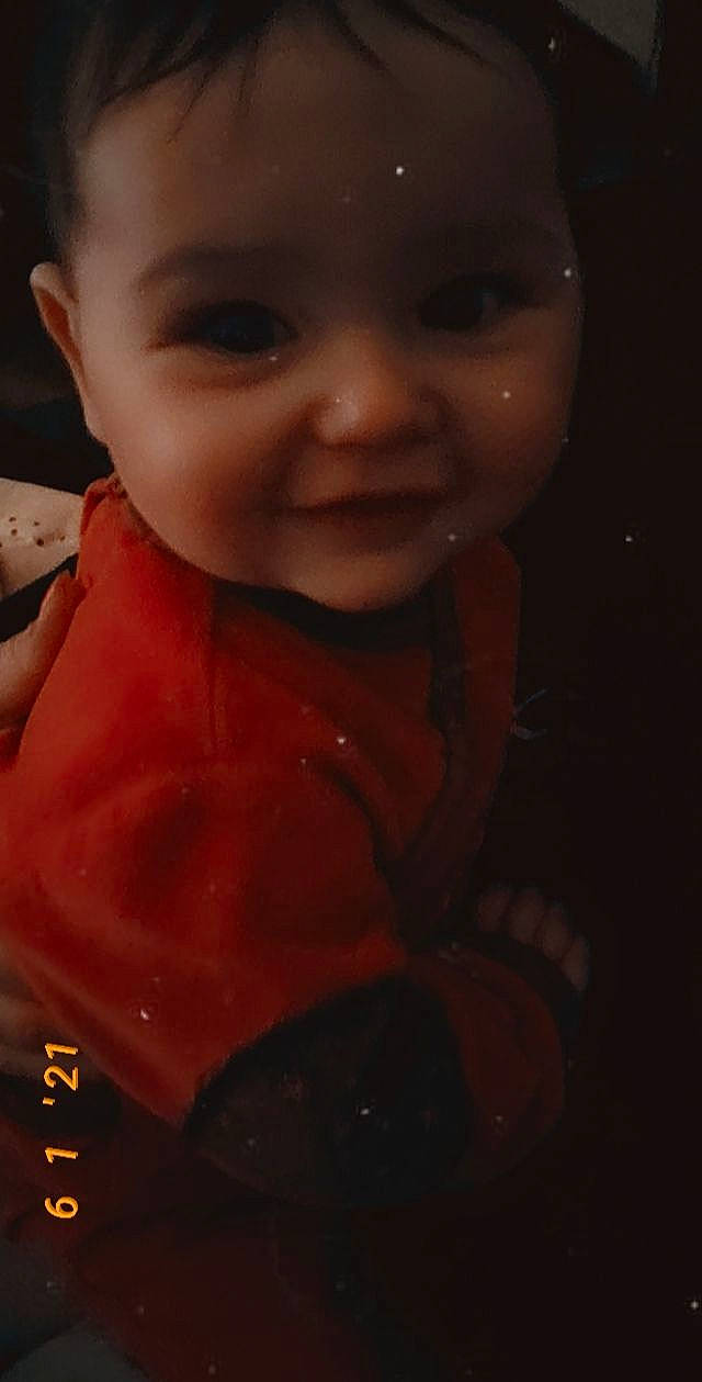 Lola participe au concours pour gagner de l'argent avec cette photo : baby, baby_toddler_clothing, cheek, child, eyebrow, eyelash, forehead, happy, iris, lip, mouth, neck, nose, pattern, person, sitting, skin, sleeve, smile, t_shirt