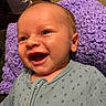 baby, smiling, face, infant, blue_onesie, knitted_blanket, purple_blanket, happy, closeup, portrait, child, skin, eyes, mouth, cozy, indoor, cute, expression, newborn, resting