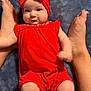 baby, infant, red_clothing, headband, feet, blanket, blue_blanket, cute, smiling, chubby_cheeks, lying_down, indoors, person, child, skin, legs, arms, soft_texture, comfort, portrait