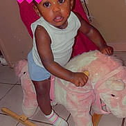 Amiriah joined the competition — help win amazing prizes! child, childhood, cute, ears, expression, floor_tiles, hair_bun, indoor, pink, playful, plush, rocking_horse, shorts, striped_socks, toddler, toy, white_shirt, white_socks, wooden_rocker, young_child