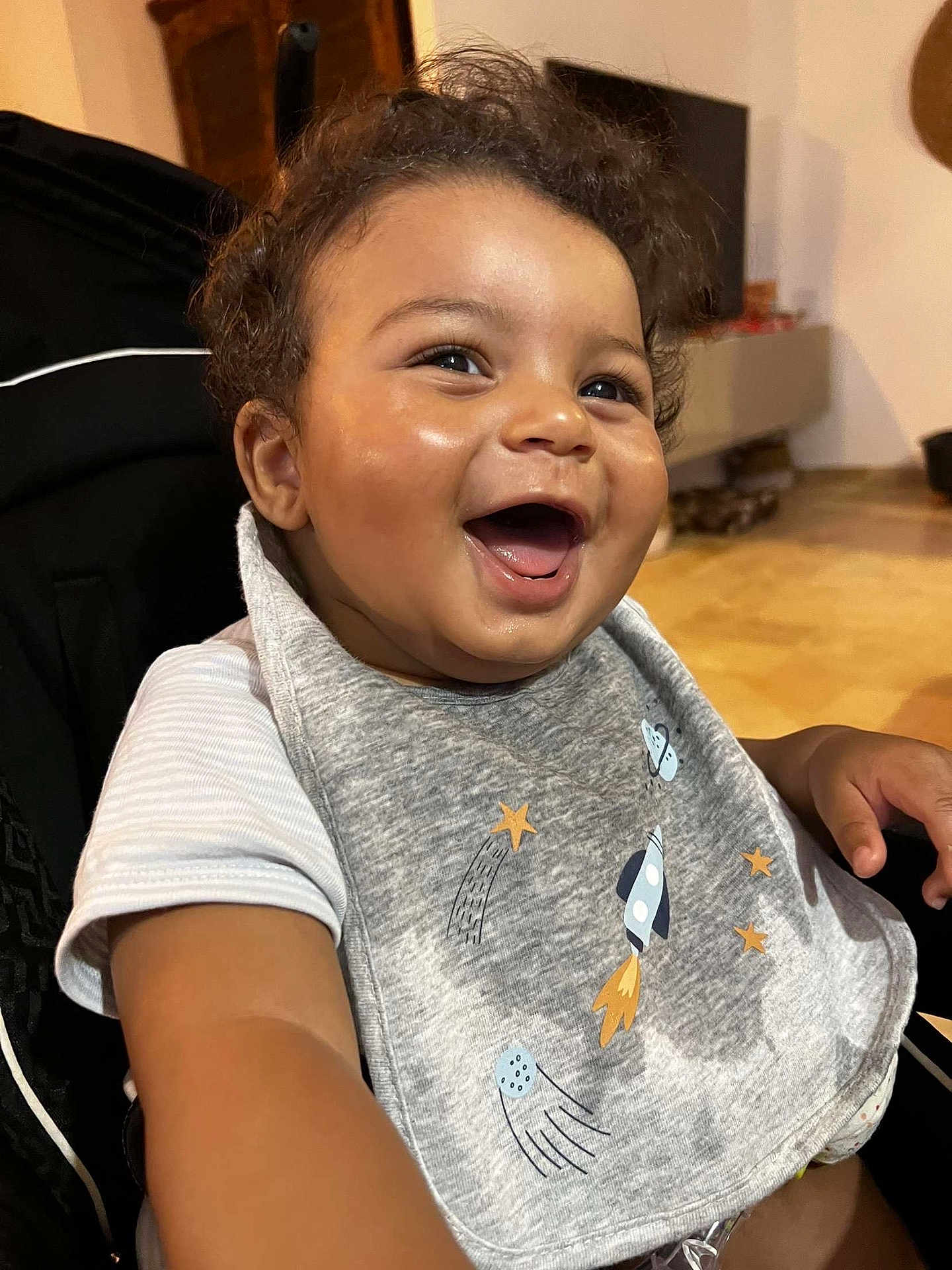 Elohïm participe au concours pour gagner de l'argent avec cette photo : baby, child, smiling, laughing, curly_hair, bib, rocket, stars, indoor, happy, toddler, clothing, face, person, seat, expression, cute, joyful, skin, infant