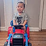toddler, child, toy, bulldozer, indoor, floor, shirt, text, face, person, vehicle, plastic, hand, expression, window, curtain, wall, door, flooring, play