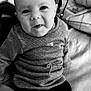 Ellie a rejoint le concours — aidez-le/la à gagner de superbes lots ! baby, infant, child, face, sitting, clothing, sweater, pants, blanket, cushion, indoor, portrait, cute, expression, soft, comfortable, young_child, home, cozy, black_and_white