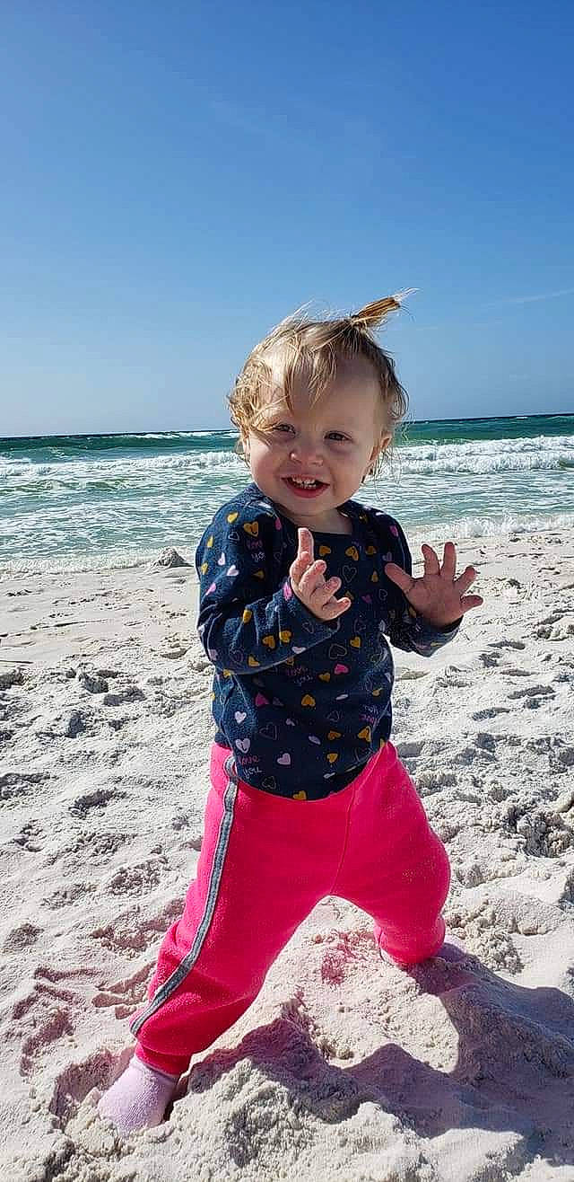 Melody is registered to the contest to win money with this photo: baby_toddler_clothing, beach, child, coast, electric_blue, eye, fun, happy, joy, leisure, ocean, people_in_nature, people_on_beach, person, sand, sky, sleeve, smile, toddler, travel