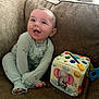 baby, child, pajamas, smiling, couch, sofa, toy, soft_toy, elephant, colorful, indoor, happy, infant, playful, seated, cute, fabric, home, furniture, portrait