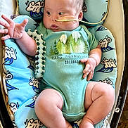 Ezekiel joined the competition — help win amazing prizes! baby, infant, onesie, blue_cushion, baby_rocker, nasal_tube, feeding_tube, hand, leg, foot, face, expression, curious, indoor, clothing, person, soft_fabric, pattern, comfort, child