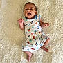 Anakin participe au concours pour gagner de l'argent avec cette photo : baby, infant, smile, happy, romper, clothing, surf, pattern, blanket, texture, lying_down, cute, child, playful, skin, face, small_hands, small_feet, indoors, portrait