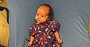 Sonny joined the competition — help win amazing prizes! baby, infant, purple_gown, patterned_clothing, blue_blanket, chair, indoor, newborn, cute, small, lying_down, curious, human, child, soft_texture, fabric, colorful, portrait, face, skin