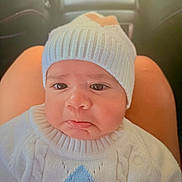 Athan joined the competition — help win amazing prizes! baby, infant, face, pout, knit_hat, sweater, clothing, person, child, indoors, car, seat, lap, cute, expression, portrait, headwear, warm_clothing, skin, young