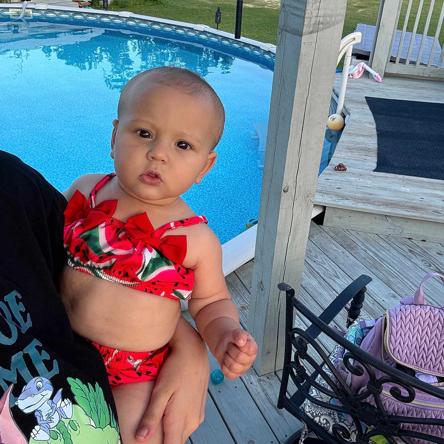 Nyana is registered to the contest to win money with this photo: baby, backyard, chair, child, clothing, curious, daylight, deck, expression, furniture, hand, holding, outdoor, person, pool, portrait, summer, swimsuit, watermelon, wood