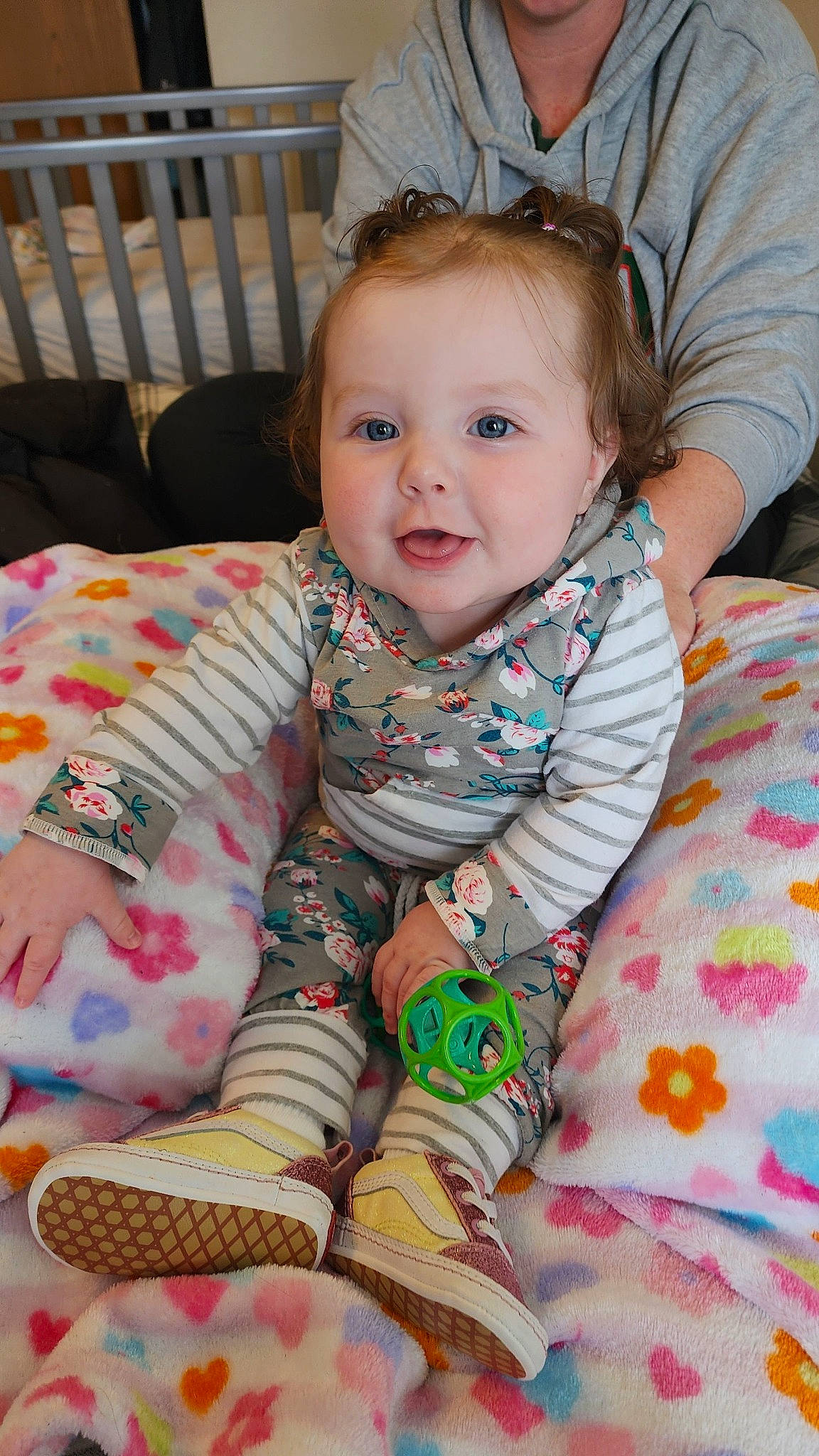 Bailey is registered to the contest to win money with this photo: arm, baby, baby_toddler_clothing, cheek, child, comfort, eye, face, happy, head, iris, linens, pattern, person, pink, room, skin, sleeve, smile, textile