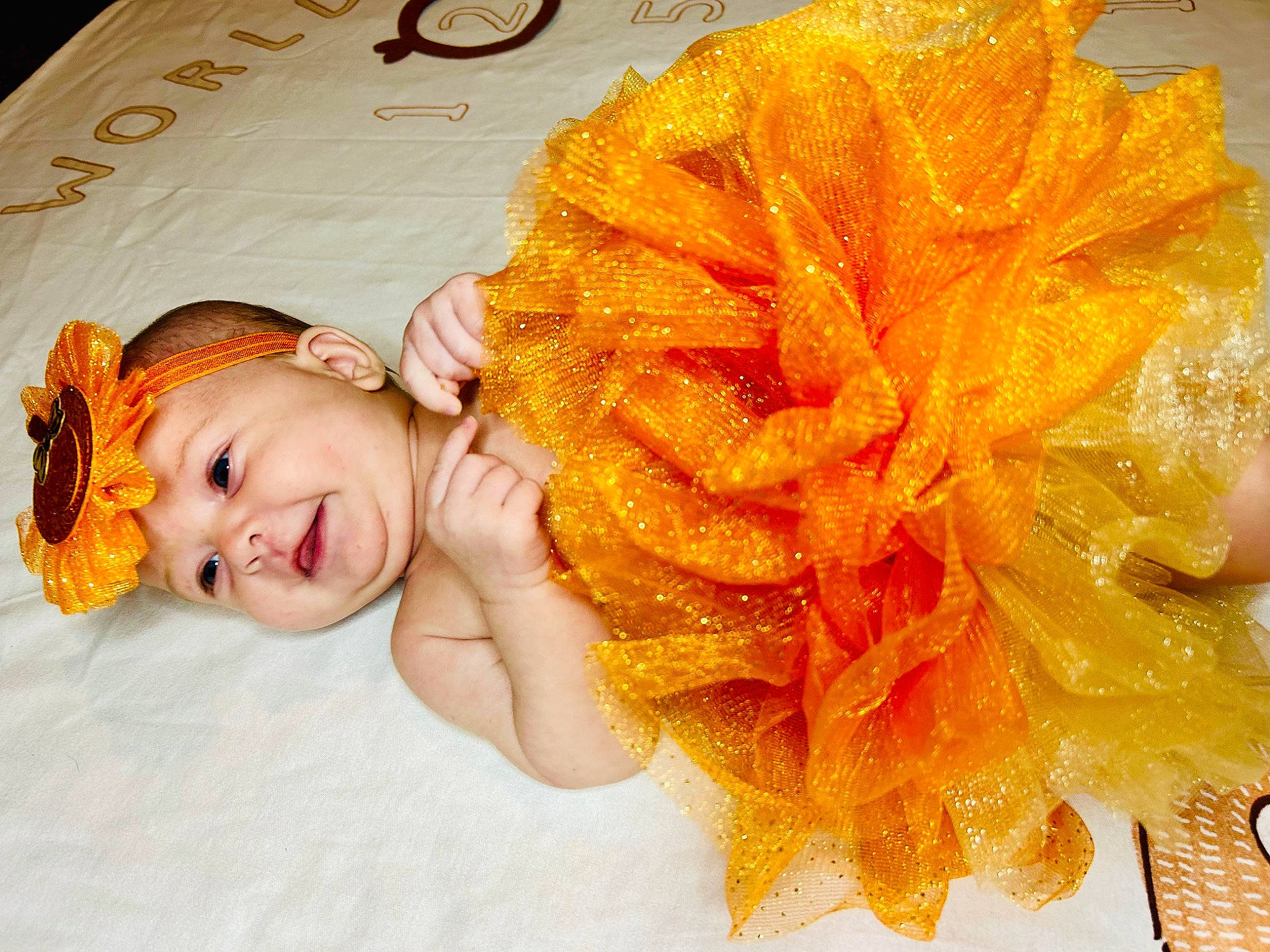 Kinsley is registered to the contest to win money with this photo: baby, baby_toddler_clothing, child, costume_accessory, craft, fashion_accessory, hair_accessory, hair_coloring, happy, headpiece, headwear, orange, pattern, peach, person, petal, portrait_photography, smile, toddler, wool