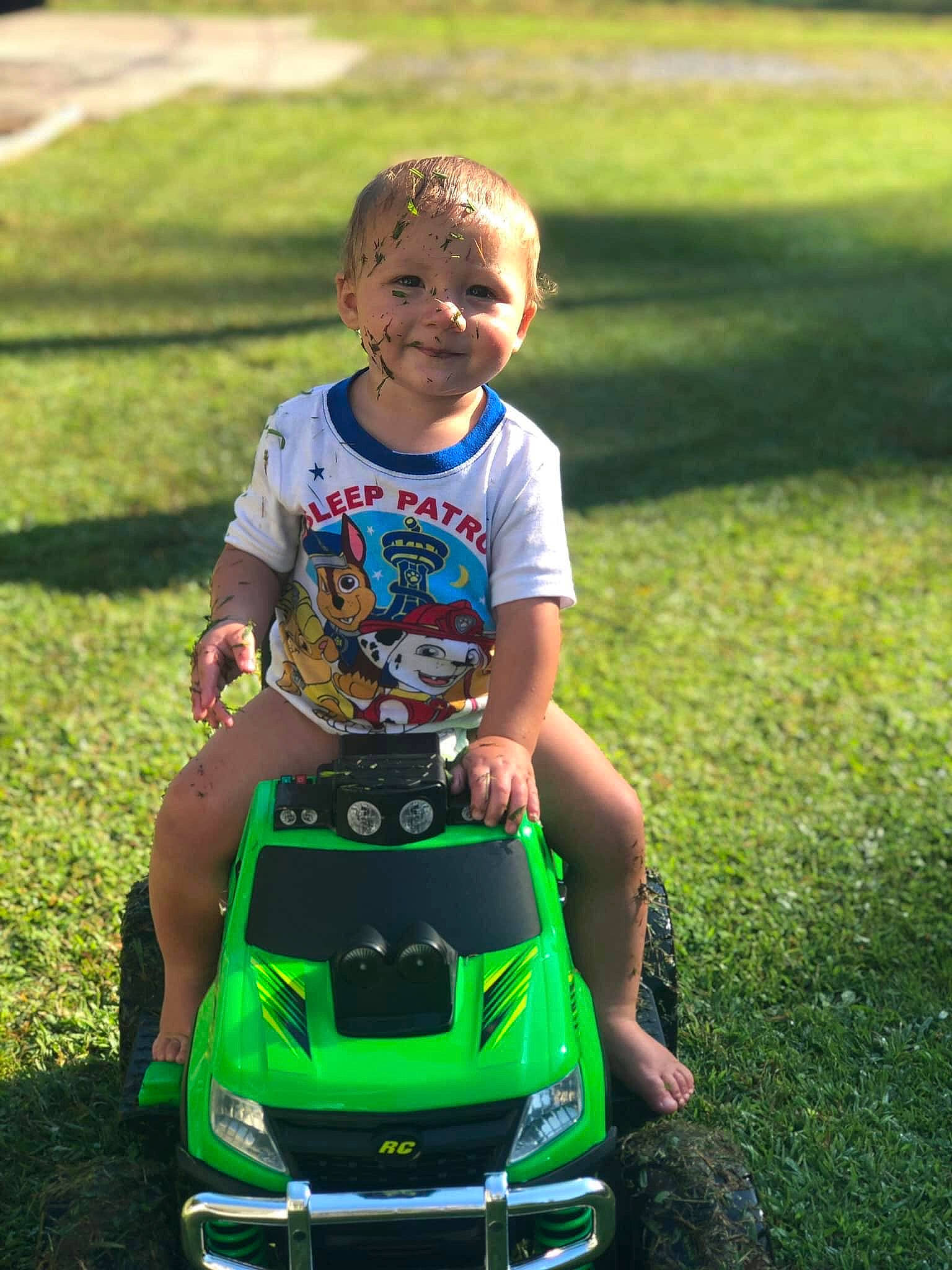 Colby is registered to the contest to win money with this photo: automotive_design, car, child, fun, grass, green, happy, joy, lawn, lawn_mower, male, mower, outdoor_power_equipment, person, plant, play, product, smile, summer, toddler