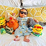 Evan joined the competition — help win amazing prizes! baby, bed, blue_outfit, child, cute, indoor, infant, person, pillow, plush_toy, relaxed, sign, sleepwear, stuffed_animal, sunglasses, toy_chicken, toy_seal, toy_turtle, two_months, yellow_toy