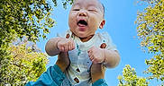 Evan is registered to the contest to win money with this photo: baby, blue_sleeves, child, cute, daylight, grass, greenery, hands, happy, joyful, nature, outdoor, park, person, playing, sky, smiling, sunflare, sunlight, trees
