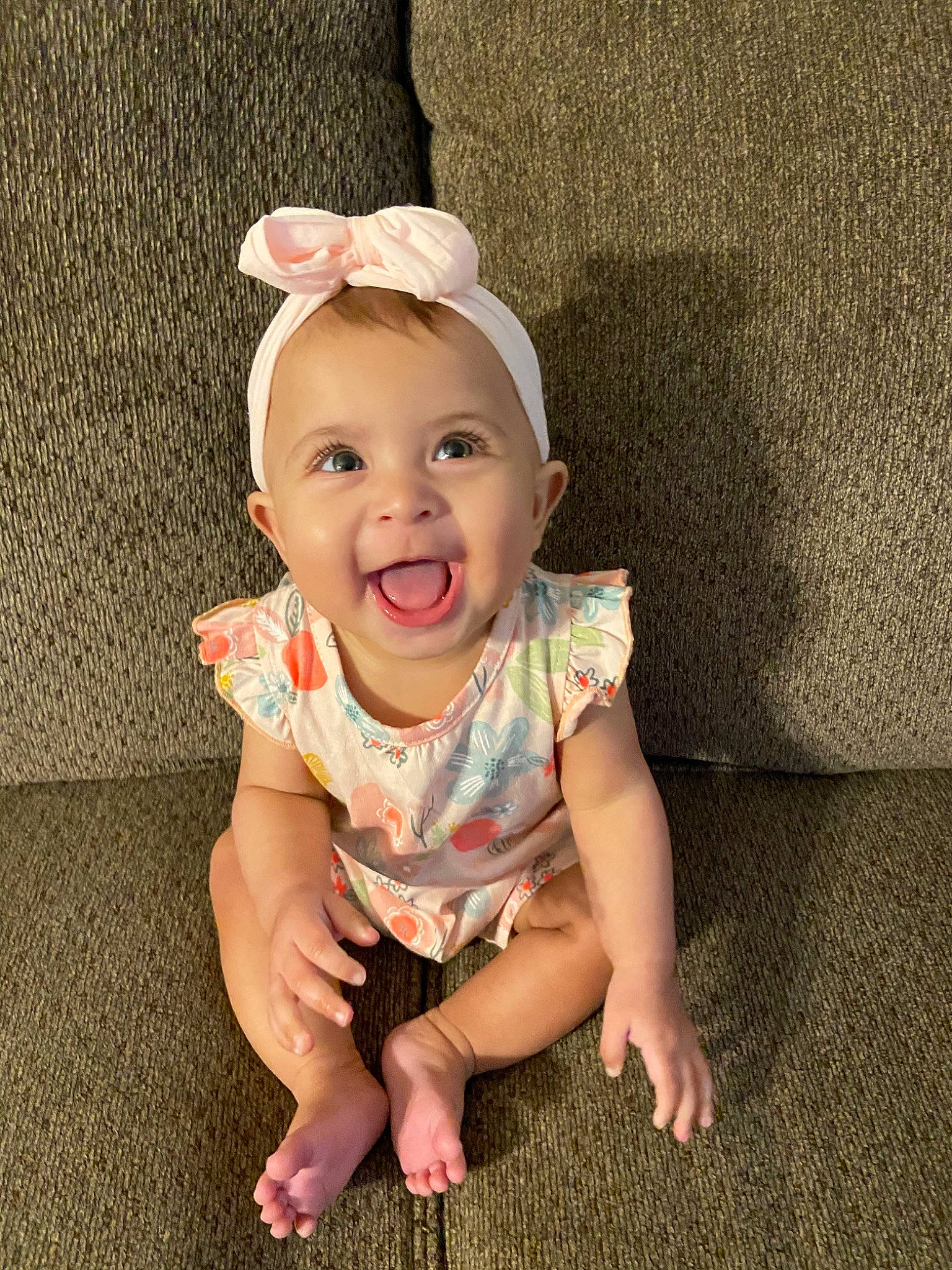 Sophia is registered to the contest to win money with this photo: baby, baby_laughing, baby_toddler_clothing, cheek, child, ear, facial_expression, floor, flooring, hair_accessory, head, headgear, leg, person, play, sitting, skin, smile, toddler