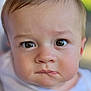 baby, face, portrait, child, close_up, expression, eyes, skin, head, infant, person, cute, young, white_clothing, soft_focus, background_blur, indoors, human, looking, serious