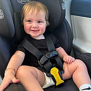 Lucas is registered to the contest to win money with this photo: accessories, baby, belt, car, car_interior, carseat, clothing, cushion, face, footwear, head, homedecor, person, photography, portrait, shoe, shorts, sitting, transportation, vehicle