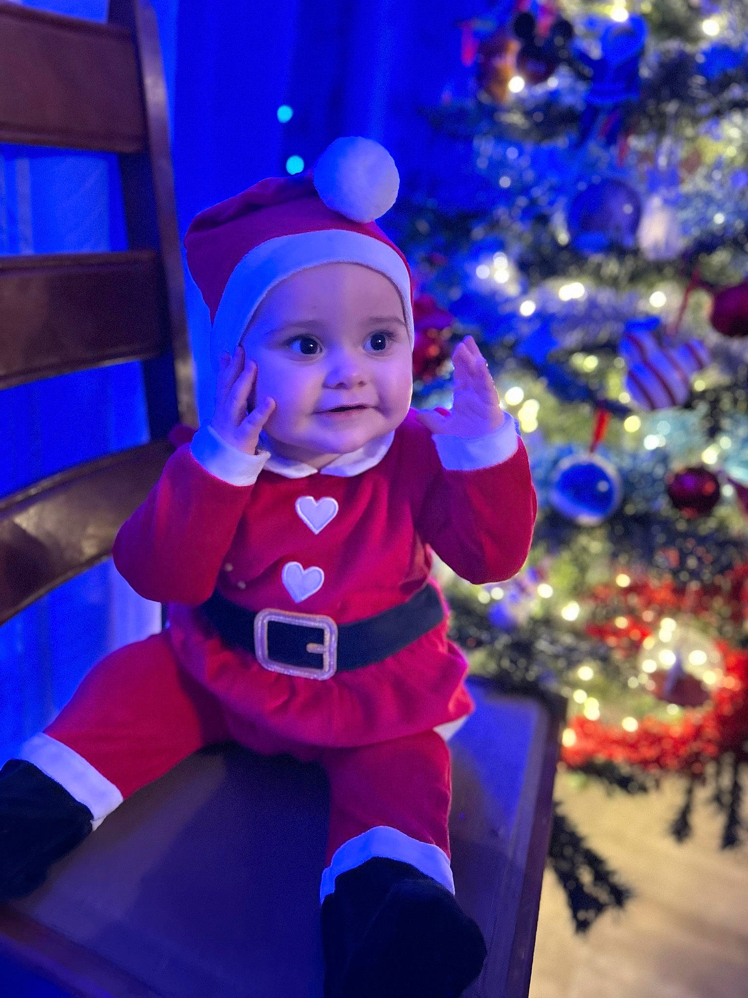 Elsa participe au concours pour gagner de l'argent avec cette photo : blue, christmas, christmas_decoration, christmas_ornament, christmas_tree, costume_hat, electric_blue, event, fun, happy, headwear, holiday, light, magenta, ornament, person, plant, purple, smile, toddler