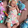 Riley is registered to the contest to win money with this photo: baby, child, bunny_ears, plush_toy, easter_eggs, pink_blanket, pastel_colors, overalls, flooring, stuffed_animal, blue_toy, purple_toy, yellow_egg, green_egg, indoor, portrait, cute, lying_down, baby_clothing, soft_toys