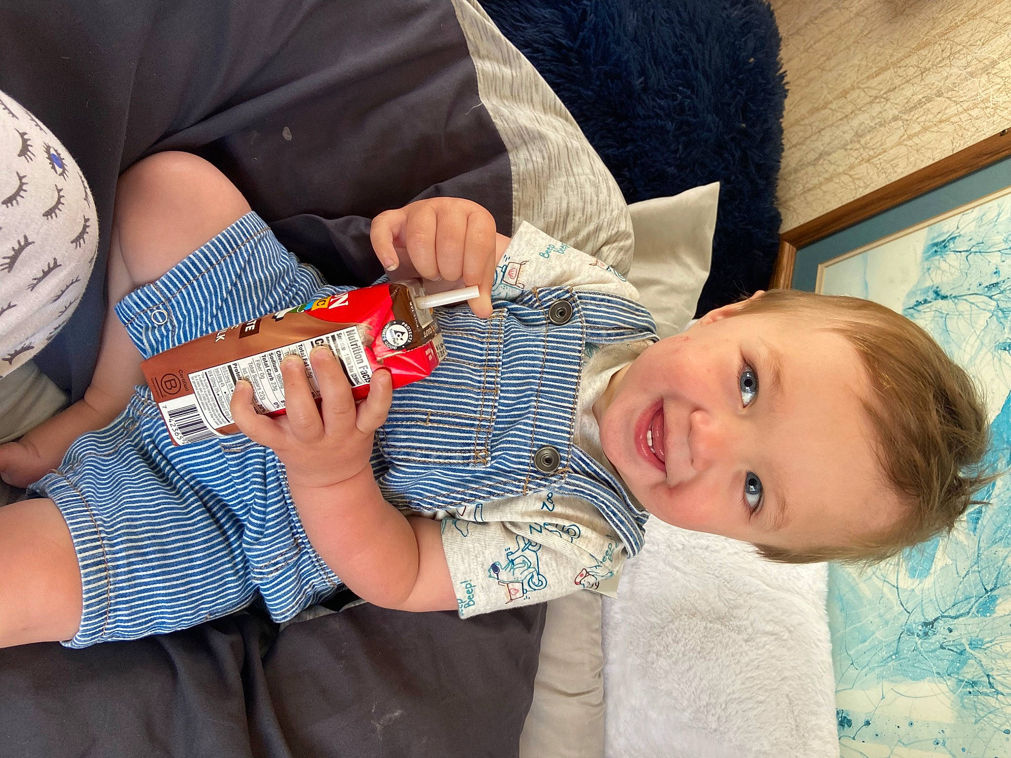 Augustus is registered to the contest to win money with this photo: child, elbow, electric_blue, finger, fun, gesture, happy, human_leg, joy, knee, lap, nail, pattern, person, play, sitting, sleeve, smile, t_shirt, thumb